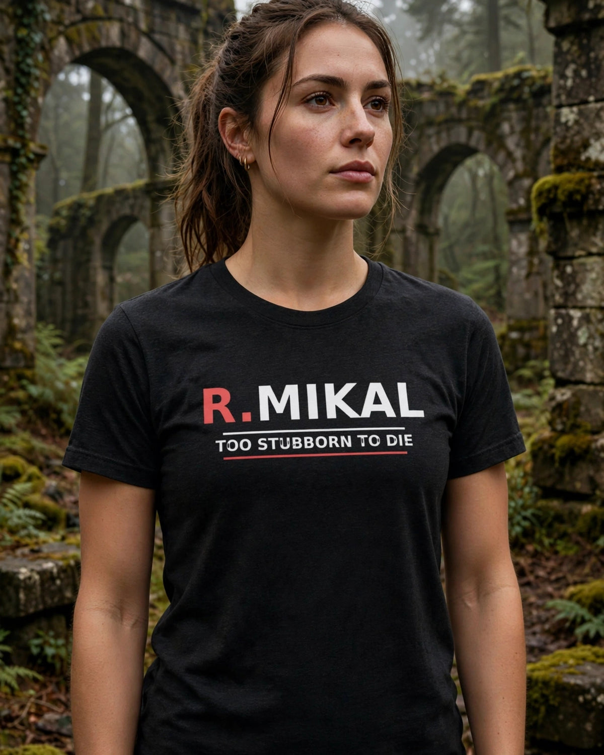 Woman wearing the black heather R.Mikal Too Stubborn to Die tee among mossy stone arches