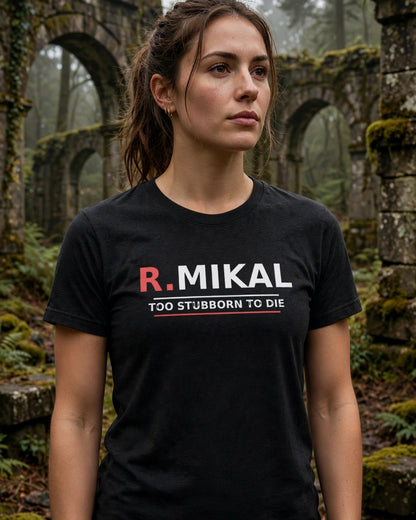 Woman wearing the black heather R.Mikal Too Stubborn to Die tee among mossy stone arches